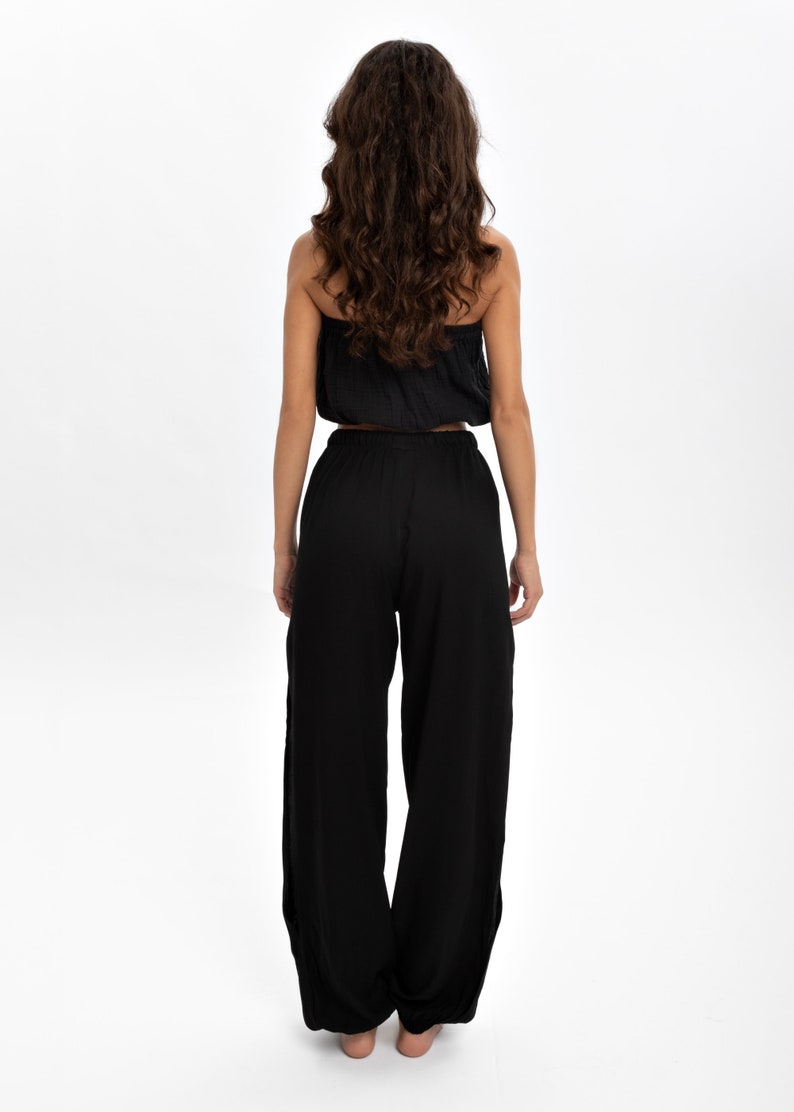 Indulge in the perfect fusion of natural comfort and bohemian elegance with these pants, meticulously crafted from 100% cotton. Their high-waist design, side slit, and tie belt seamlessly combine fashion with practicality.