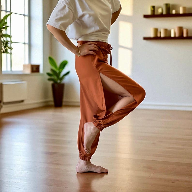 Indulge in the perfect fusion of natural comfort and bohemian elegance with these terra cotta pants, meticulously crafted from 100% cotton. Their high-waist design, side slit, and tie belt seamlessly combine fashion with practicality.