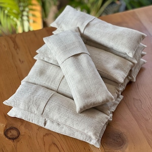 Neatly stacked linen eye pillows in neutral tones, perfect for yoga retreats, spas, and wellness centers.