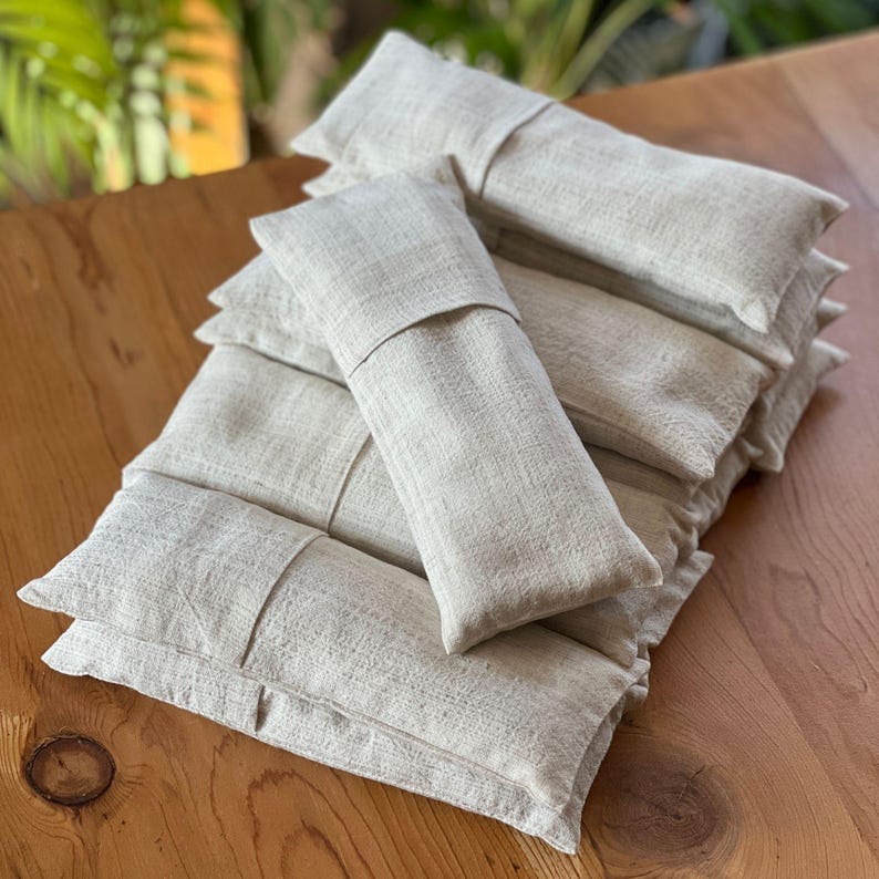 Neatly stacked linen eye pillows in neutral tones, perfect for yoga retreats, spas, and wellness centers.