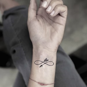 May include: A temporary tattoo of an infinity symbol with an arrow pointing to the right.