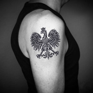 May include: A black and white tattoo of a stylized eagle with a crown on its head. The eagle is a traditional symbol of Poland.