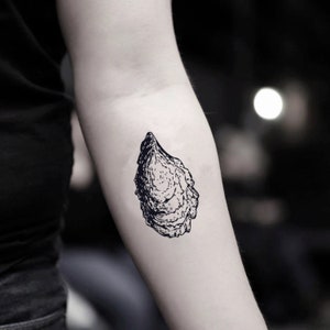 May include: A black and white line drawing of an oyster shell on a person's arm.