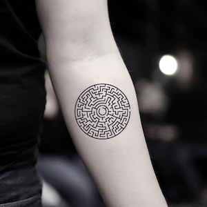 Puede incluir: Un tatuaje temporal en blanco y negro con un diseño de laberinto circular.