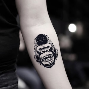 Könnte beinhalten: Schwarz-Weiß-Illustration eines Gorillagesichts mit offenem Mund und sichtbaren Zähnen. Das Fell des Gorillas ist detailliert, und das Bild ist ein Tattoo-Design.
