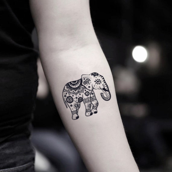 Minimalistic elephant tattoo located on the wrist, fine