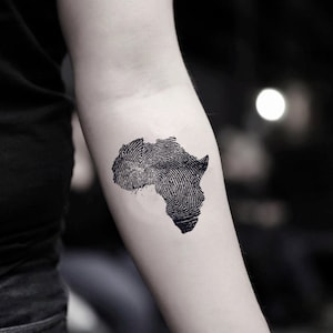 Peut inclure: Un tatouage temporaire du continent africain, conçu pour ressembler à une empreinte digitale.
