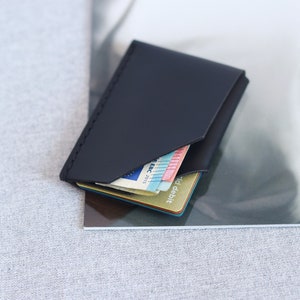 Black leather card holder, sleek wallet on the table.