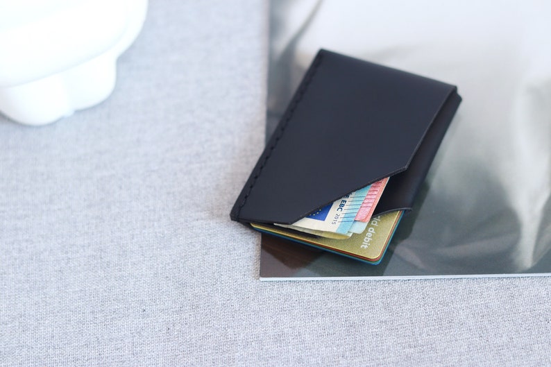 Black leather card holder, sleek wallet on the table.