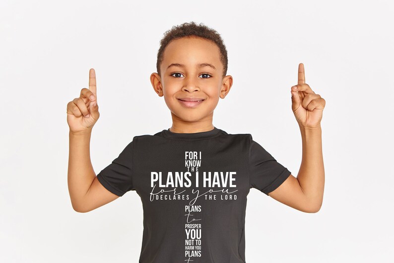 May include: A young boy wearing a black t-shirt with a white graphic that reads "For I know the plans I have for you, declares the Lord. Plans to prosper you, not to harm you, plans to give you hope and a future."