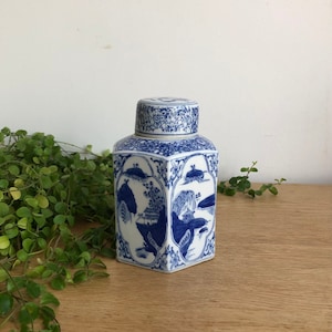 Op de afbeelding: Een zeshoekige theedoos van blauw-wit porselein met een deksel. De doos is versierd met een traditionele Chinese landschapsscène.