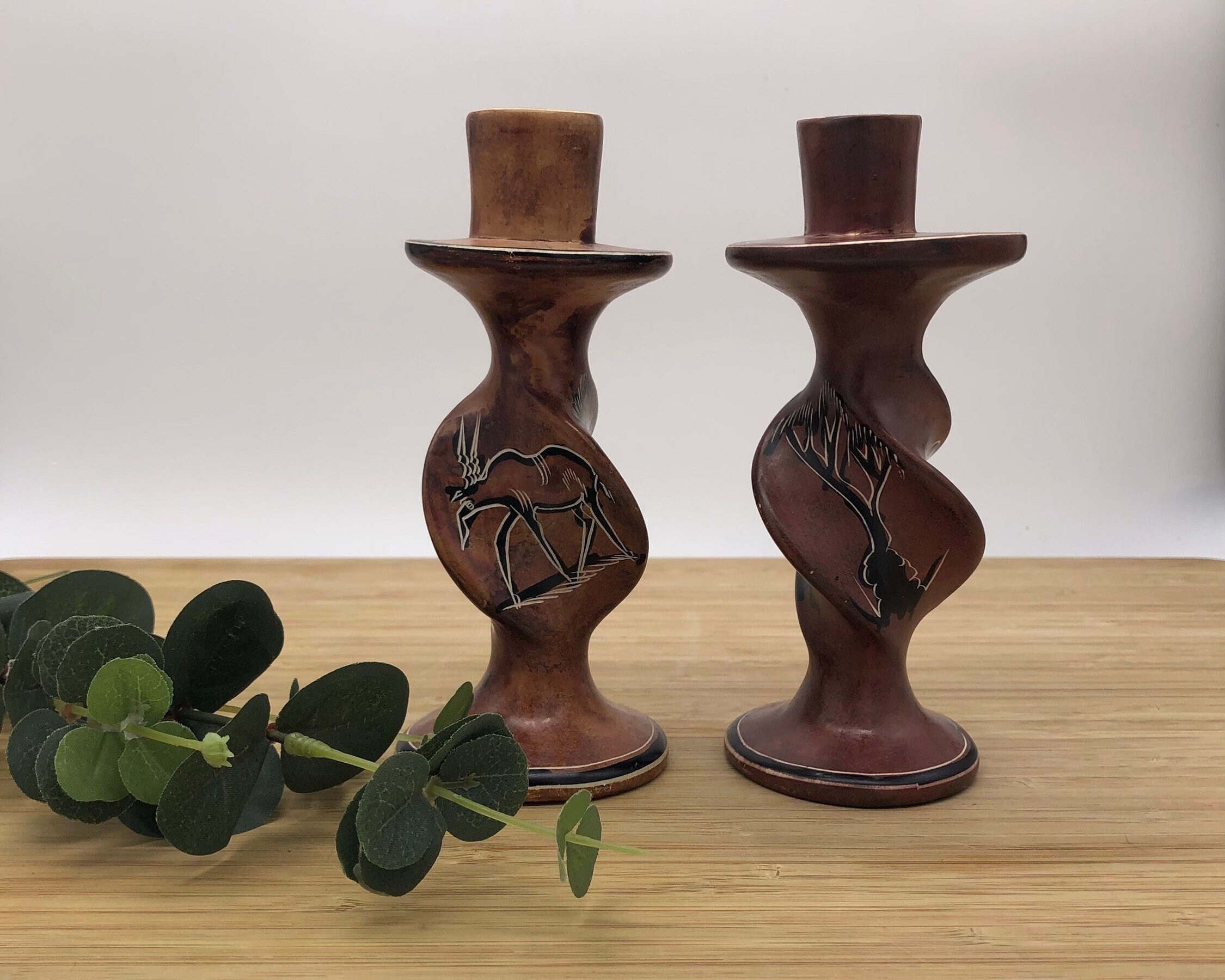 Set of 2 vintage African turned soapstone candlesticks. Handmade. In brown tones, with African animal and plant motifs.