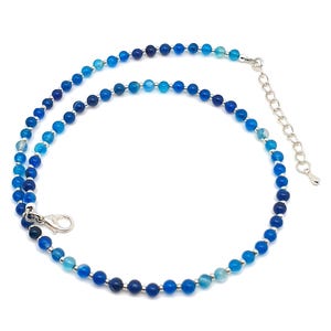 Beaded blue Agate necklace, made with small round gemstone beads interspaced with tiny silver plated glass seed beads, strung on flexible silicon plated steel beading wire. Finished with silver plated brass lobster claw clasp and extension chain.