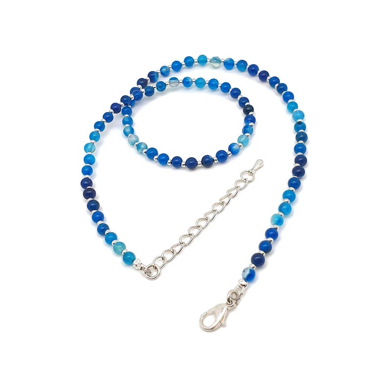 Beaded blue Agate necklace, made with small round gemstone beads interspaced with tiny silver plated glass seed beads, strung on flexible silicon plated steel beading wire. Finished with silver plated brass lobster claw clasp and extension chain.