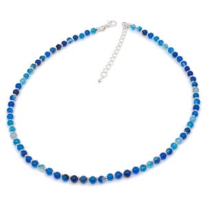 Beaded blue Agate necklace, made with 4 mm round gemstone beads interspaced with 2 mm silver plated glass beads, strung on flexible silicon plated steel beading wire. Finished with silver plated brass lobster claw clasp and extension chain.