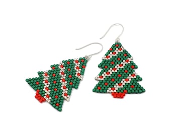 Op de afbeelding: Een paar kerstboom oorbellen. De oorbellen zijn groen met rode en witte accenten en hebben zilverkleurige haken. De oorbellen zijn gemaakt van kleine kralen en hebben de vorm van een kerstboom.