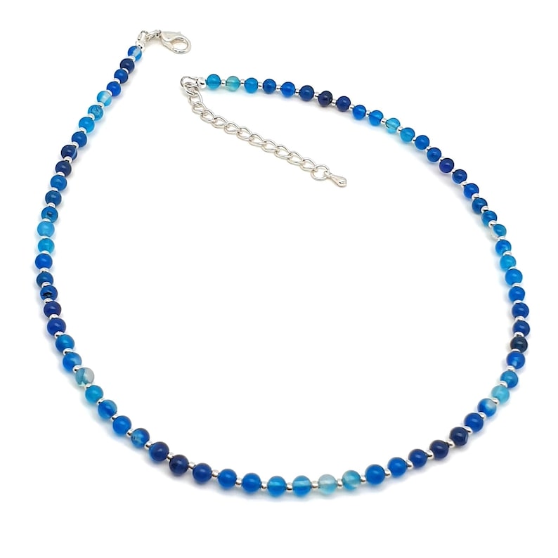 Beaded blue Agate necklace, made with small round gemstone beads interspaced with tiny silver plated glass seed beads, strung on flexible silicon plated steel beading wire. Finished with silver plated brass lobster claw clasp and extension chain.