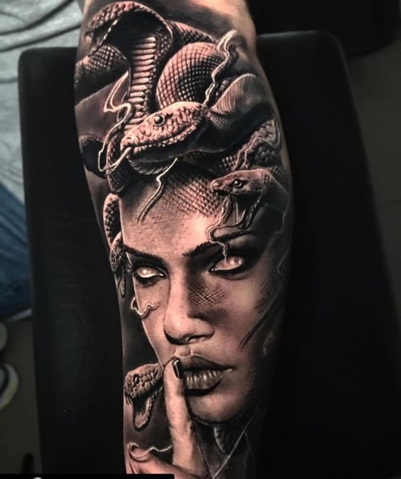 May include: Black and white tattoo of a woman's face with snakes for hair. The woman's eyes are white and she has a serious expression. The snakes are realistic and detailed.
