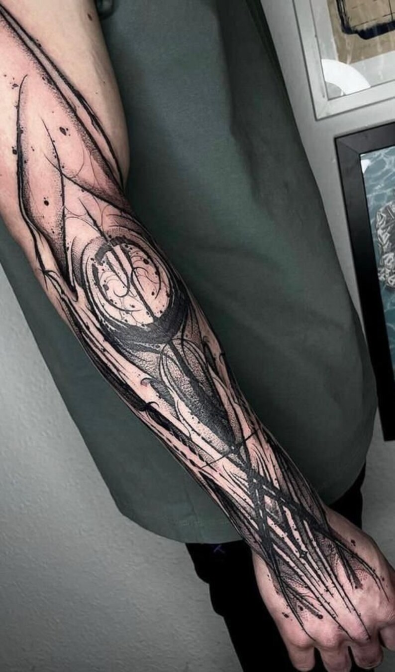 May include: Black and white abstract tattoo design on a person's forearm. The design features intricate lines and swirls.