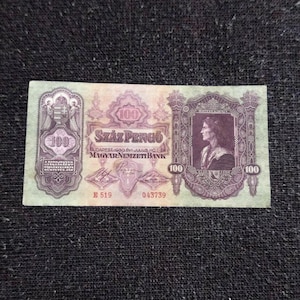 May include: A 1930 Hungarian 100 Pengő banknote featuring a portrait of Mátyás Király on the right, the Hungarian coat of arms on the left, and the text Száz Pengő, Budapest, 1930. Évi Július Hó 1-én, and Magyar Nemzeti Bank in purple ink.
