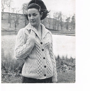 May include: A black and white photo of a woman wearing a knitted cardigan with a honeycomb collar. The cardigan is buttoned up the front and has a pocket on each side. The text on the image reads "REGENCY BAININ DOUBLE KNITTING LADY'S JACKET with HONEYCOMB COLLAR Sizes 36, 38, 40 and 42 REGENCY WOOLS LTD LEAFLET No. 16 9d."
