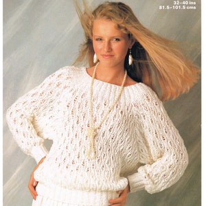 Könnte beinhalten: Eine Frau trägt einen weißen Strickpullover mit offenem Gewebe und einen Rock. Der Pullover hat einen U-Boot-Ausschnitt und lange Ärmel. Das Bild enthält den Text "Marriner 2019" und "Silky Cotton 81.5-101.5 cms".