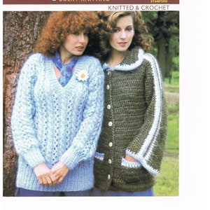 May include: Two women wearing knitted sweaters. The woman on the left is wearing a light blue sweater with a v-neck and a daisy pin. The woman on the right is wearing a green sweater with a white collar and white stripes on the sleeves. The sweaters are both knitted in a bulky yarn.