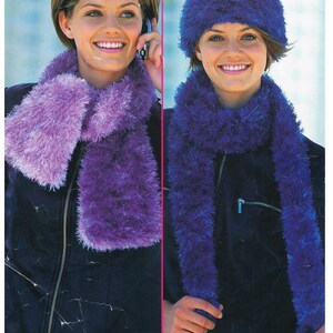 Op de afbeelding: Afbeelding van een vrouw met een pluizige paarse sjaal en bijpassende muts. De sjaal is lang en rechthoekig, en de muts is een nauwsluitende beanie-stijl. De afbeelding toont ook de tekst "Funky Fur Fashion Yarn" en "Sirdar".