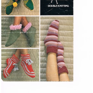 May include: A collection of knitted slipper and sock designs. The image shows various styles, including green slippers with yellow pom-poms, green slippers with pink trim, red slippers with gray stripes and tassels, and striped socks. The Emu Double Knitting logo is visible.