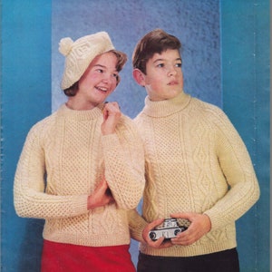 May include: A knitting pattern for a cream Aran sweater with a crew neck and a matching tam. The pattern is called "Aran" and is from the "Sunbeam" brand. The pattern includes sizes for 30, 32, 34, and 36 inches and requires 24, 26, 28, or 30 ounces of yarn.