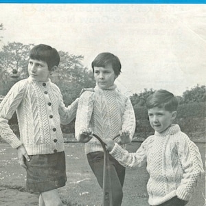 Puede incluir: Tres niños con suéteres de punto blanco con patrones de trenza. Los suéteres están disponibles en las tallas 24, 26, 28, 30 y 32. El texto "REGENCY WOOLS LTD" está impreso en la parte superior de la imagen. El texto "LEAFLET No. 24 9d." está impreso en la esquina superior derecha de la imagen.