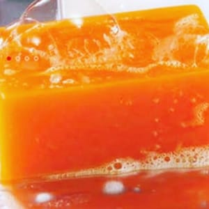 May include: A bright orange bar of soap with white bubbles forming around it.