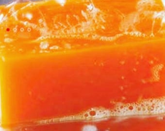 Op de afbeelding: Een feloranje zeepstaaf met witte bubbels die eromheen ontstaan.
