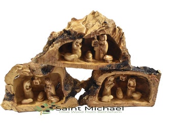 Peut inclure: Une crèche de Noël en trois parties sculptée dans du bois d'olivier, représentant la naissance de Jésus dans une crèche. Les figurines sont sculptées avec soin et le bois a une finition naturelle et rustique. La scène est installée dans un morceau de bois d'olivier creusé, créant un décor unique et magnifique.