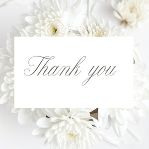 May include: A white card with the text "Thank you" written in a cursive font, surrounded by white flowers.