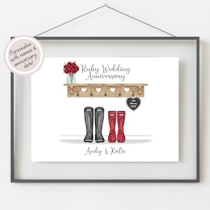 May include: A personalised Ruby Wedding Anniversary print featuring a wooden shelf with two pairs of wellies, a bouquet of red flowers, and a chalkboard heart with the date "14th February 2022". The names "Andy & Katie" are written below the shelf.