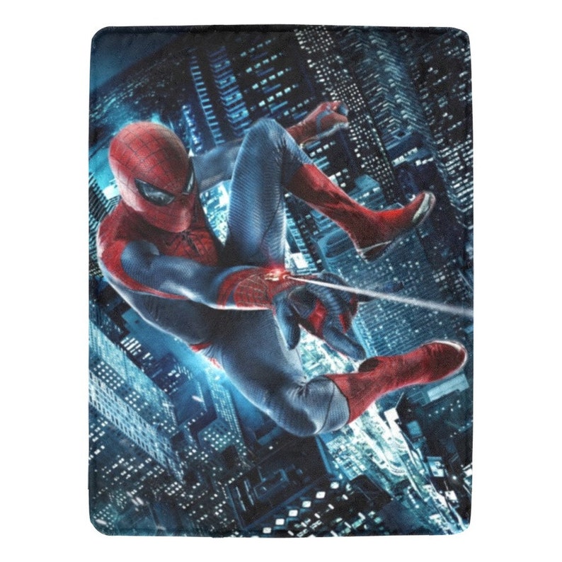 Pu&ograve; includere: Un supereroe rosso e blu, Spiderman, si dondola attraverso una citt&agrave; di notte. Indossa un costume rosso e blu con un logo di ragno sul petto. Si dondola da una linea di ragnatela. La citt&agrave; &egrave; illuminata da luci.
