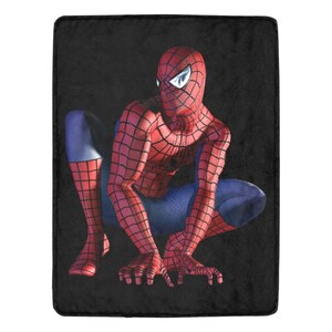 Op de afbeelding: Een rood en blauw Spider-Man-personage in een hurkende pose op een zwarte achtergrond.