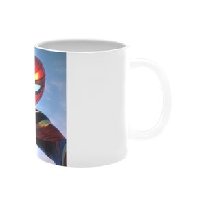 Puede incluir: Taza de cer&aacute;mica blanca con una imagen colorida de Spider-Man en el lateral. La taza tiene un asa en el lado derecho.