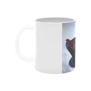 Puede incluir: Taza de cer&aacute;mica blanca con una imagen colorida de un superh&eacute;roe en el aire, sobre un fondo de cielo azul.