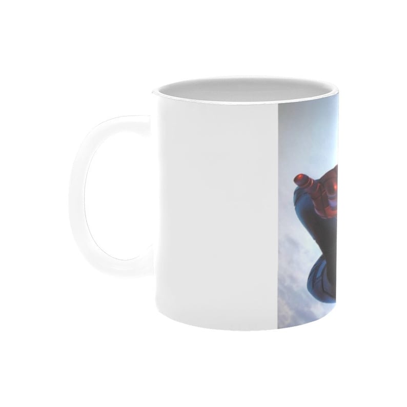 Puede incluir: Taza de cer&aacute;mica blanca con una imagen colorida de un superh&eacute;roe en el aire, sobre un fondo de cielo azul.