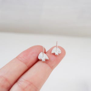 May include: A pair of silver stud earrings with a spade design. The spades are covered in small, clear crystals.