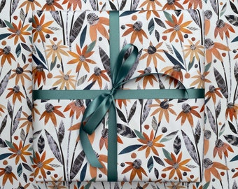 May include: A white gift wrap with a repeating pattern of orange, brown, and blue flowers. A teal ribbon is tied in a bow on top of the wrapping paper.