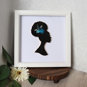 Lady in a black picture frame, black with blue flowers
