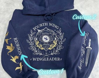 May include: A navy blue hoodie with a white design on the front that says "Fourth Wing" and "Wingleader". The left sleeve has a gold dragon design and the right sleeve has a white design that says "Violent Little Thing".