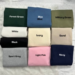 Op de afbeelding: Een verzameling stofstalen in verschillende kleuren, waaronder bosgroen, blauw, legergroen, wit, ivoor, zand, zwart, lichtroze, marineblauw en sportgrijs.