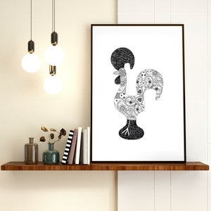 May include: Black and white line art print of a rooster with a detailed patterned design. The rooster is the national symbol of Portugal. The print is framed and hanging on a white wall above a shelf with books and vases.