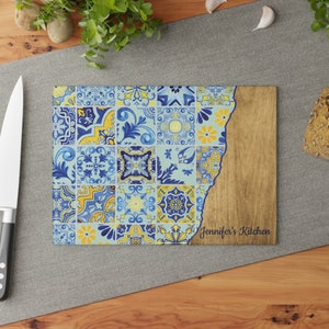 May include: A blue and yellow patterned chopping board with a wood border. The board has a jagged edge and the text "Jennifer's Kitchen" is printed on the wood.