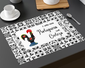 May include: Black and white placemat with a Portuguese rooster design. The placemat has a white background with black floral patterns and a white rectangle in the center with the text "é uma casa Portuguesa com Certeza".