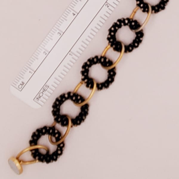 Chocolate Sprinkles Donut Bracelet, round links with pebbly black and gold surface are connected with large oval jump rings, magnet clasp